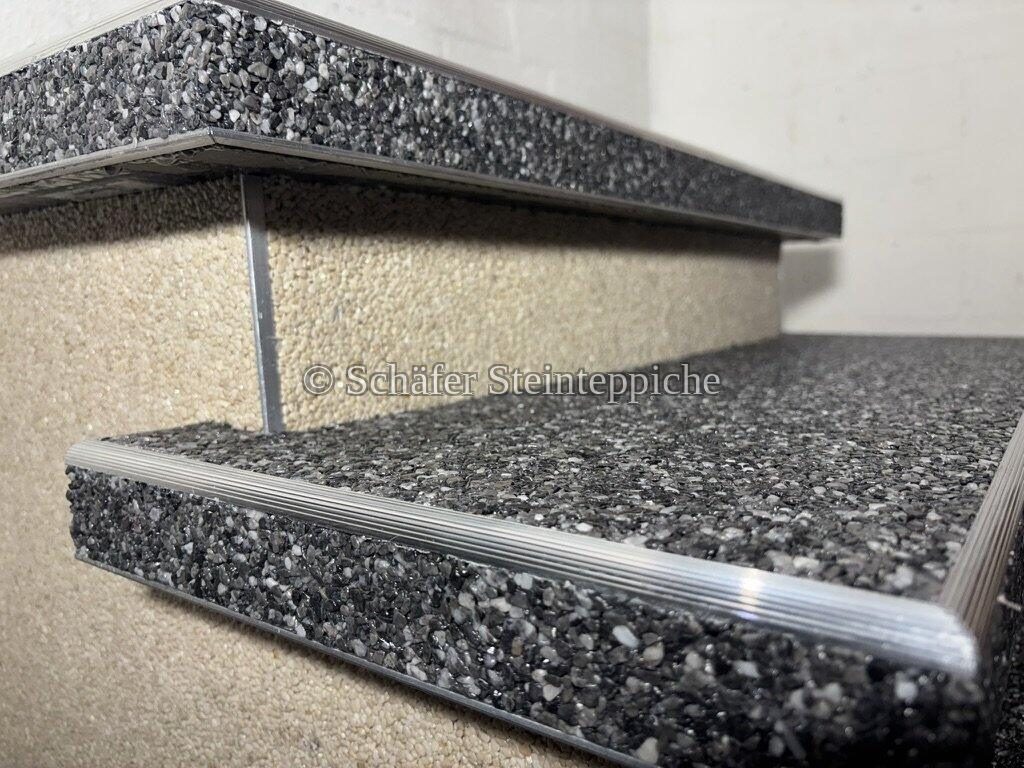 Nahaufnahme zweier Steinteppich-Stufenkanten mit Aluminiumprofil